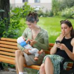 Heels Damage - two women sitting on a bench with a baby