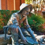 Shoe Styles Change - a statue of a man sitting on a rock