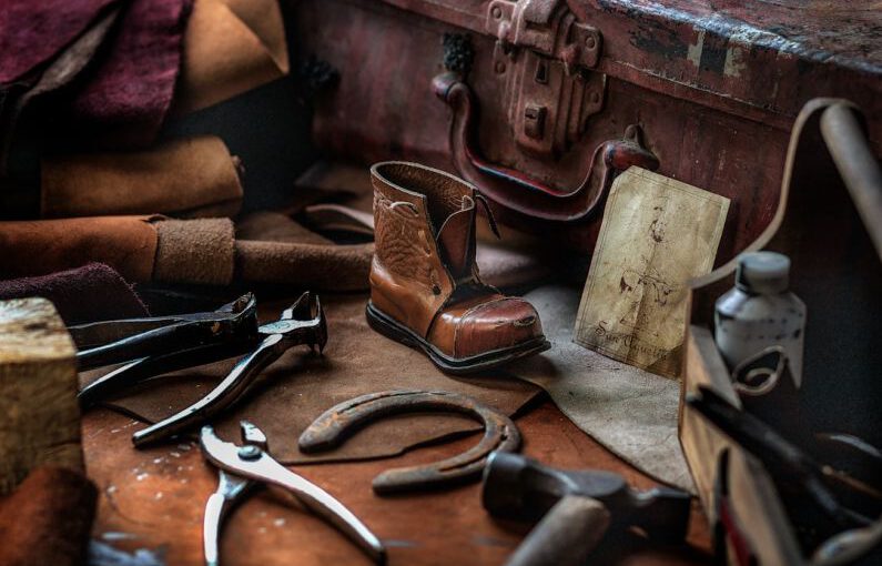 Shoe Repair - assorted hand tools with unpaired brown work boot