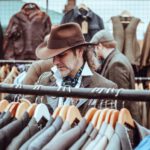 Online Shoes Shopping - man in brown cowboy hat in front of hanged suit jackets
