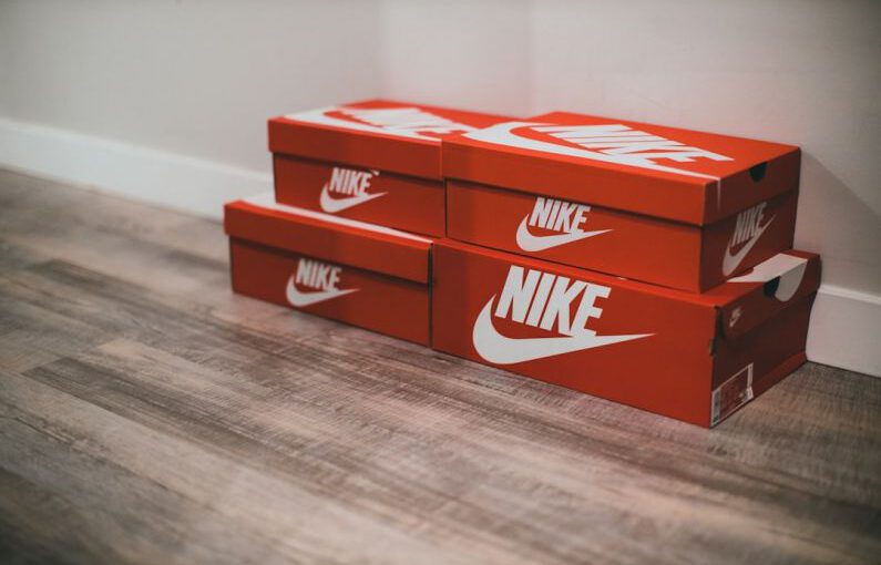 Personalized Sneakers - a pair of red nike boxes sitting on top of a wooden floor