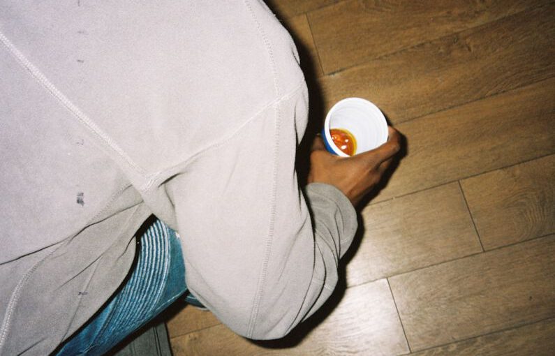 Iconic Shoes - person in gray pants holding white plastic cup