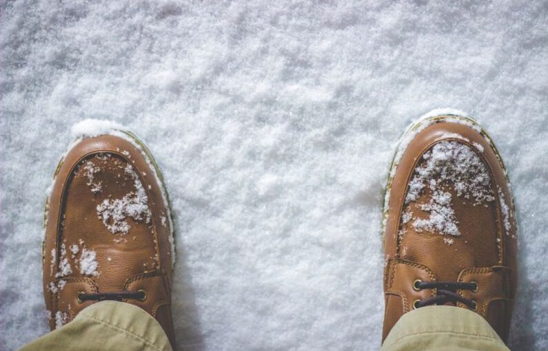 Shoes Battles - top view photography of person standing on snow covered field